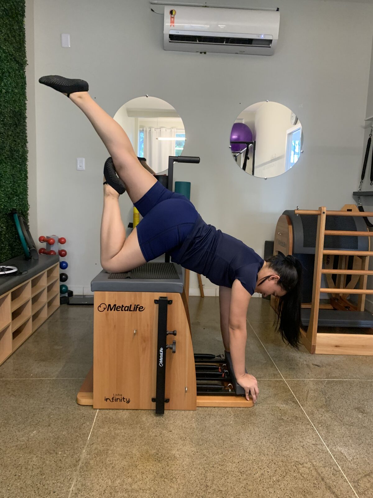 Aluna em exercício de força e equilíbrio na cadeira de pilates
